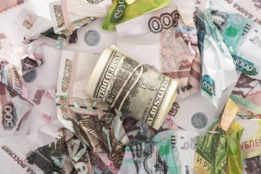 Buruşuk ruble banknotların yanında dolarlarla nakit akışının üst görüntüsü 