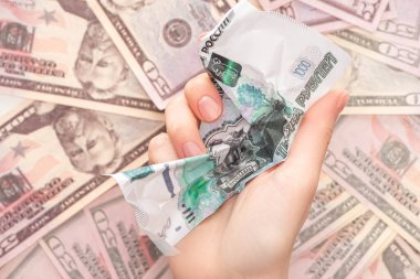 Dolarların yanında buruşuk ruble banknot tutan bir kadın. 