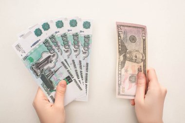 KYIV, UKRAINE - 25 Mart 2020: Beyaz üzerinde izole edilmiş Rus rublesi ve dolar banknotları tutan kadının üst görüntüsü 