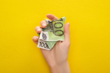 Kırışmış Avro banknotunu sarıya sarılmış bir şekilde tutan kadın manzarası