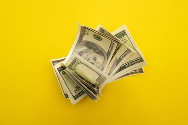 Sarı üzerine izole edilmiş dolar banknotlarının üst görünümü 
