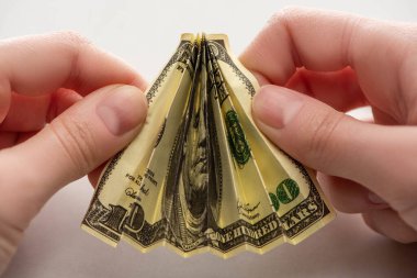 Kırpılmış bir kadının elinde buruşmuş bir dolar banknotuyla beyaz ellerle... 