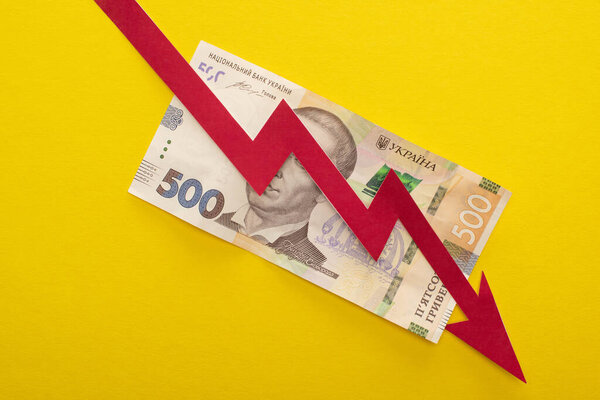 KYIV, UKRAINE - MARCH 25, 2020: top view of crisis graph on ukrainian hryvnia banknote isolated on yellow 