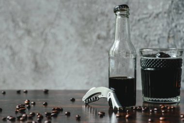 cold brew coffee in glass and bottle near opener and coffee beans clipart