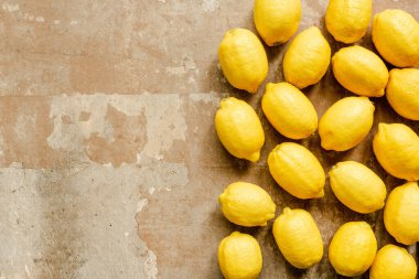 Yıpranmış yüzeyde olgun sarı limonların üst görüntüsü