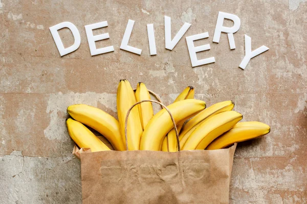 Top View Word Delivery Paper Bag Bananas Beige Weathered Surface — Stock Photo, Image