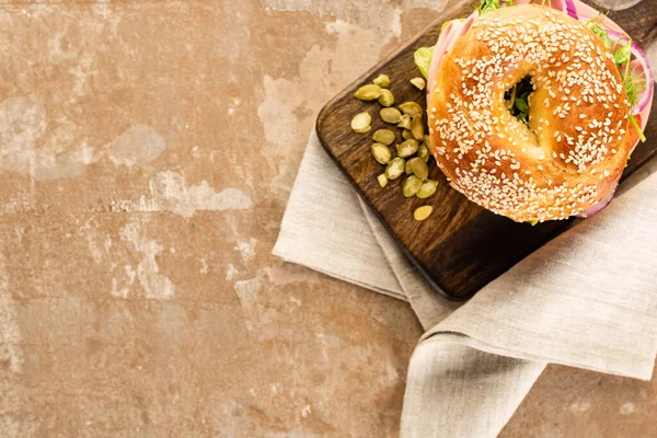 Draufsicht Auf Frischen Leckeren Bagel Auf Holzschneidebrett Mit Kürbiskernen Auf — Stockfoto