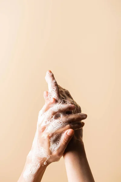 妇女用从米色分离出来的肥皂泡沫洗手的局部视图 — 图库照片