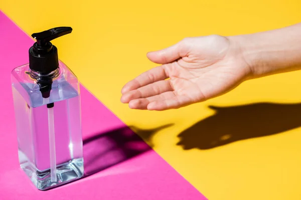 Частичный Вид Женской Руки Возле Бутылки Дезинфицирующим Средством Розовом Желтом — стоковое фото