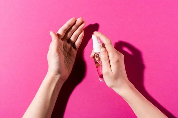 Pandangan Parsial Dari Wanita Penyemprotan Pembersih Tangan Pada Pink — Stok Foto