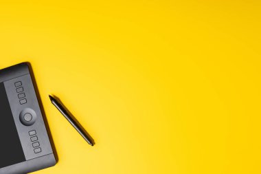 Sarı üzerine tablet ve stil çiziminin üst görünümü