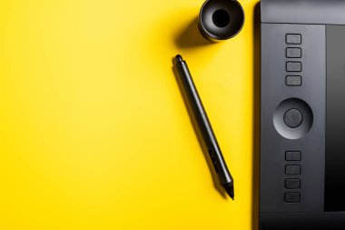 Siyah çizim tabletinin üst görünümü, stil ve sarı üzerinde tutucu 