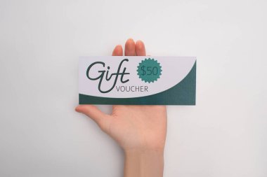 Beyaz arka planda 50 dolar tabelası olan hediye çeki tutan bir kadın.
