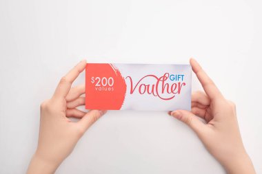 Beyaz arkaplanda değerler yazan hediye çeki tutan kadının üst görünümü