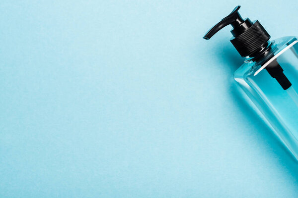 top view of hand sanitizer in transparent bottle with dispencer on blue