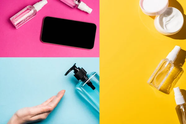 彩色烘焙场消毒液附近洗涤剂 手霜和智能手机附近女性手的拼贴 — 图库照片