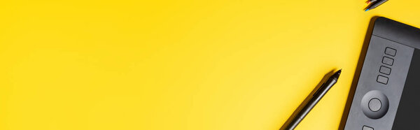 panoramic crop of drawing tablet and stylus on yellow