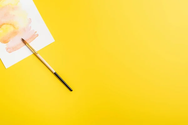 Yaratıcı Resmin Yanındaki Boya Fırçasının Üst Görüntüsü Sarı Renkte Izole — Stok fotoğraf