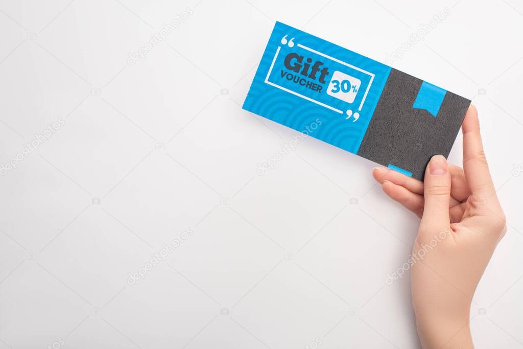 Top view of woman holding gift voucher with 30 percents sign on white background
