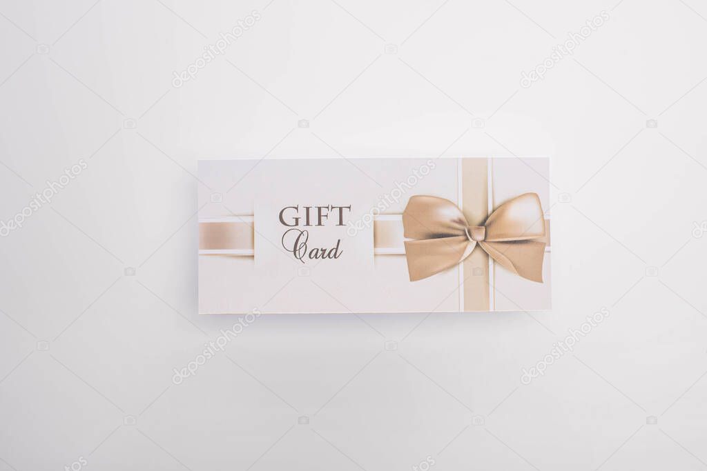 Top view of gift card with bow on white background