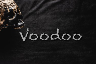 occult skull near voodoo lettering on black  clipart