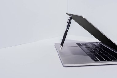beyaz arkaplanda modern dizüstü bilgisayarda kalem