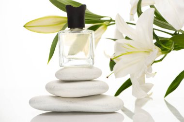 home perfume in bottle near spa stones and lilies on white background clipart
