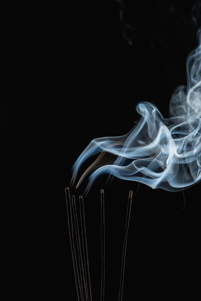 жжение ароматные палочки с дымом на черном фоне
