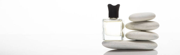 home perfume in bottle near spa stones on white background, panoramic shot