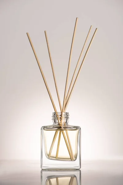木製の棒で香水瓶の中ベージュの背景 — ストック写真