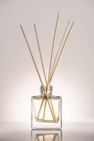 wooden sticks in perfume in bottle on beige background