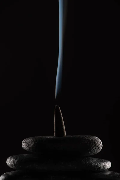 Räucherkegel Mit Rauch Auf Steinen Auf Schwarzem Hintergrund — Stockfoto