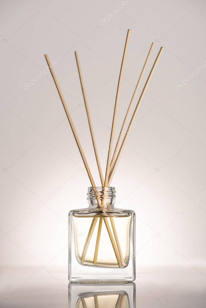 wooden sticks in perfume in bottle on beige background