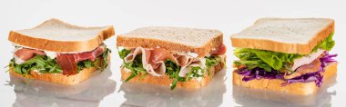 Avokado ve jamonlu taze yeşil sandviçler mermer beyaz yüzey, panoramik çekim