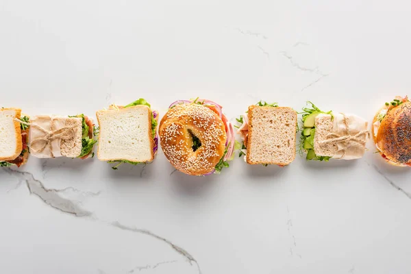 Deitado Plano Com Sanduíches Frescos Bagel Superfície Branca Mármore — Fotografia de Stock