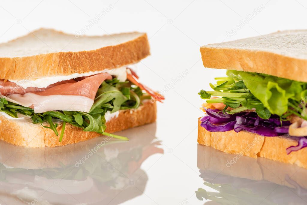 fresh green sandwiches with prosciutto on white surface