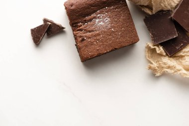 Beyaz arkaplanda çikolata olan lezzetli browni parçasının üst görüntüsü
