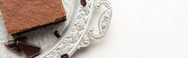 Kahve çekirdekleri ve beyaz arka planda gümüş tepside çikolata ile nefis browni parçasının üst görüntüsü, panoramik çekim