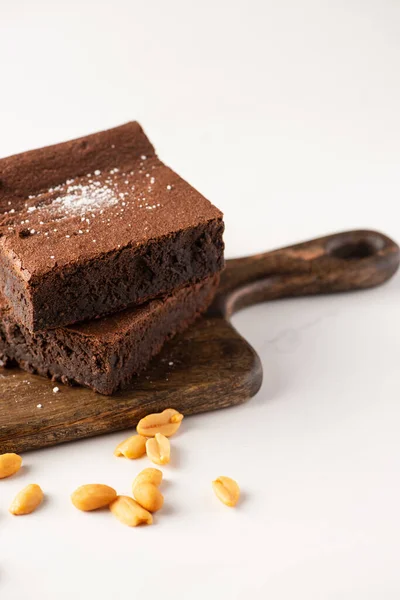 Leckere Brownie Stücke Auf Holzschneidebrett Mit Erdnüssen Auf Weißem Hintergrund — Stockfoto