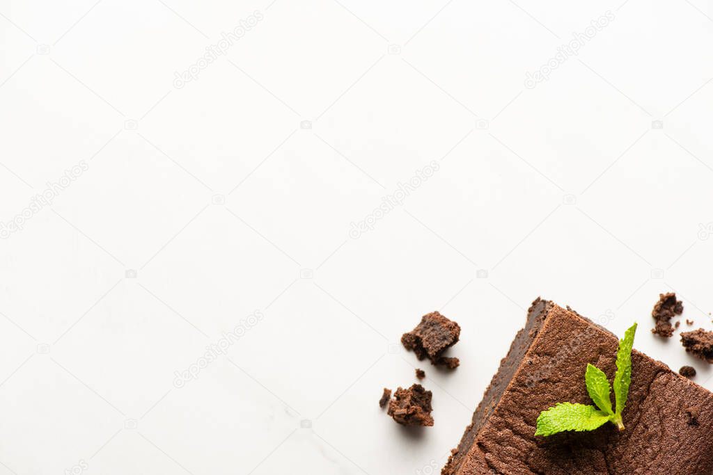 top view of delicious brownie piece with mint on white background