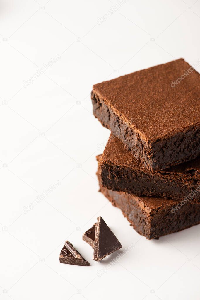 delicious brownie pieces with dark chocolate on white background
