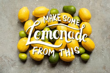 Gri beton yüzeyde renkli avokado, limon ve limon manzarası, bu resimden biraz limonata yap.