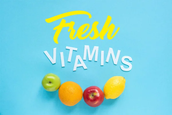 蓝色背景的成熟水果和新鲜维生素词汇的顶视图 — 图库照片