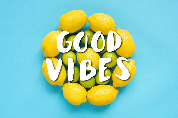 top view of ripe yellow lemons and limes arranged in circles on blue background, good vibes illustration