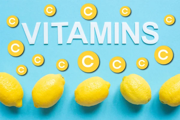 Bovenaanzicht Van Rijpe Gele Citroenen Woord Vitaminen Blauwe Achtergrond — Stockfoto