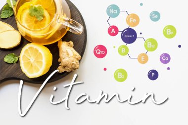 Çaydanlıktaki sıcak çayın beyaz zemin üzerinde zencefil kökü, limon ve nane ile sunulduğu ahşap panoda servis edilen görüntüsü, vitamin illüstrasyonu