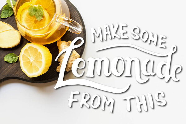 верхний вид горячего чая в чайнике подается на деревянной доске с корень имбиря, лимон и мята на белом фоне, сделать некоторые лимонад из этой иллюстрации
