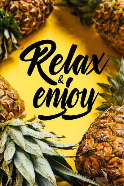 selective focus of fresh ripe pineapples with green leaves on yellow background with relax and enjoy illustration