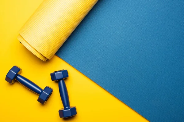 Vista Superior Alfombra Fitness Azul Con Mancuernas Sobre Fondo Amarillo — Foto de Stock