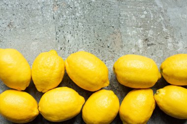 Beton desenli yüzeyde olgun sarı limonların üst görüntüsü